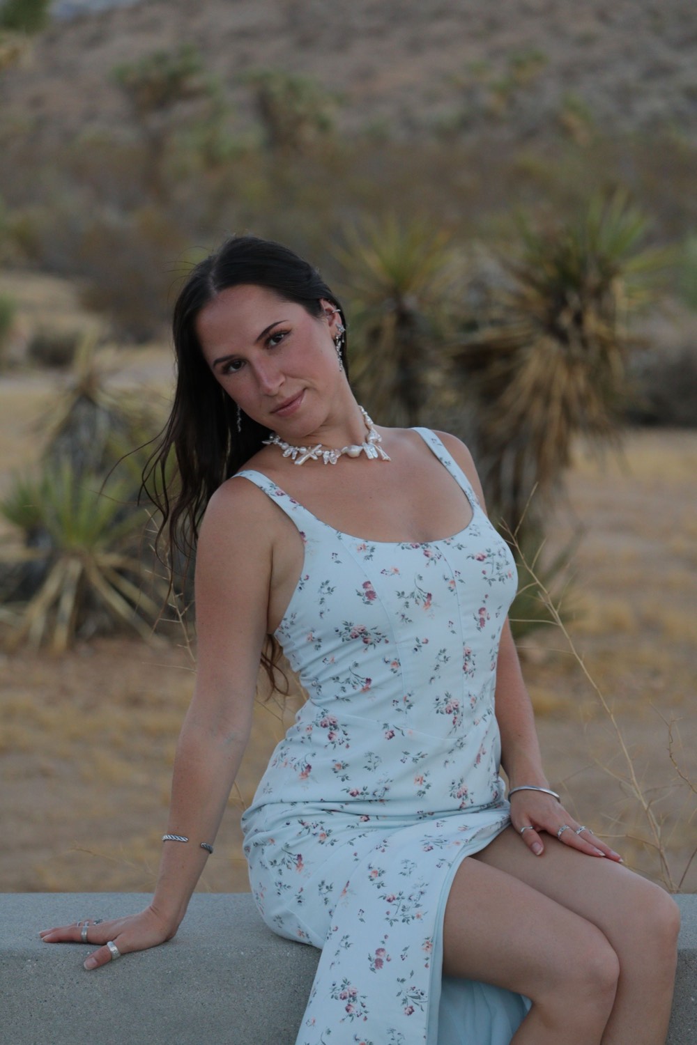 Jenny Hobbs sitting outdoors in the desert at golden hour